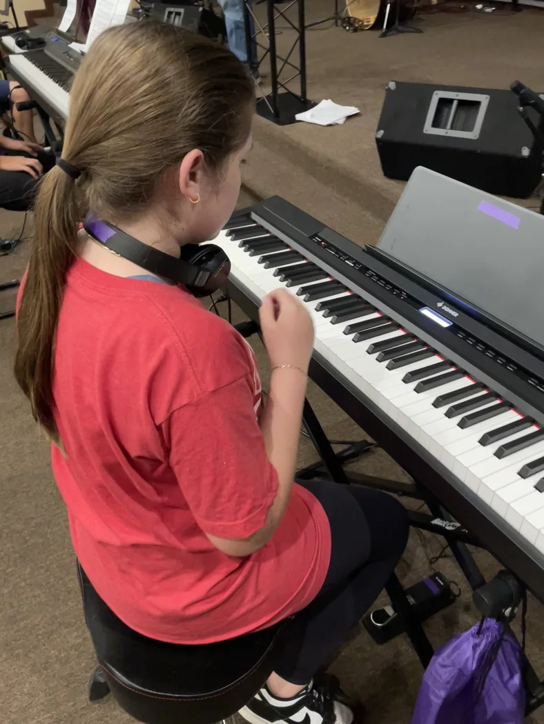Student learning at a keyboard with headphones
