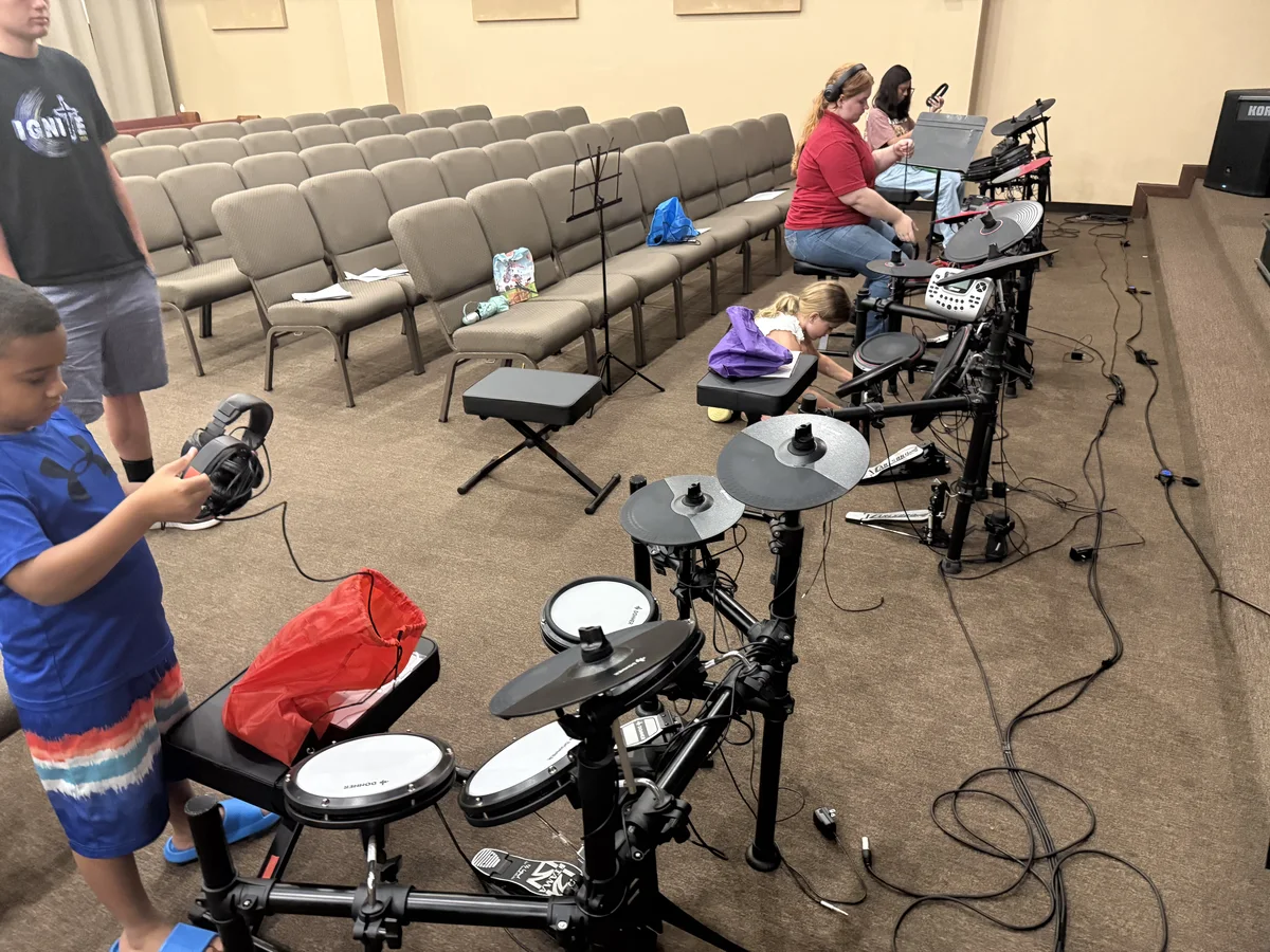Students learning together at electronic drums