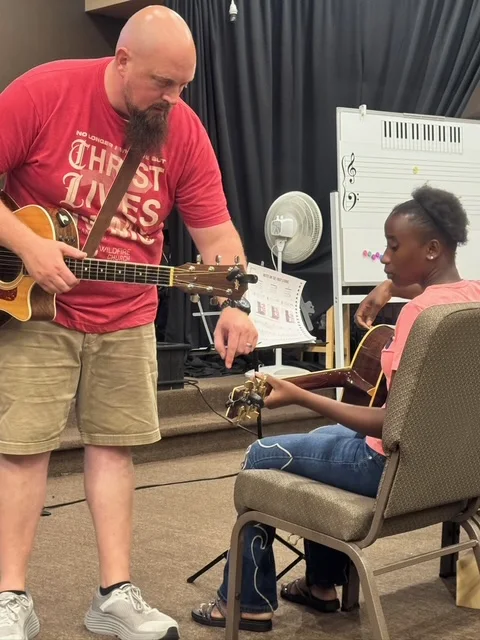 Spark Academy student receiving guitar instruction
