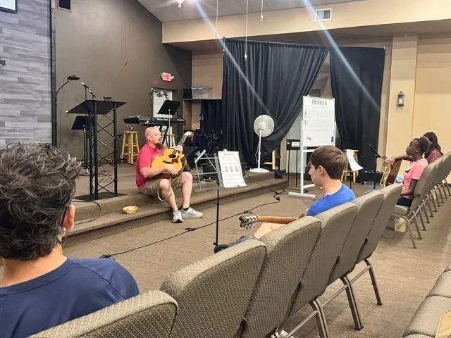 Spark Academy students learning together in a guitar class