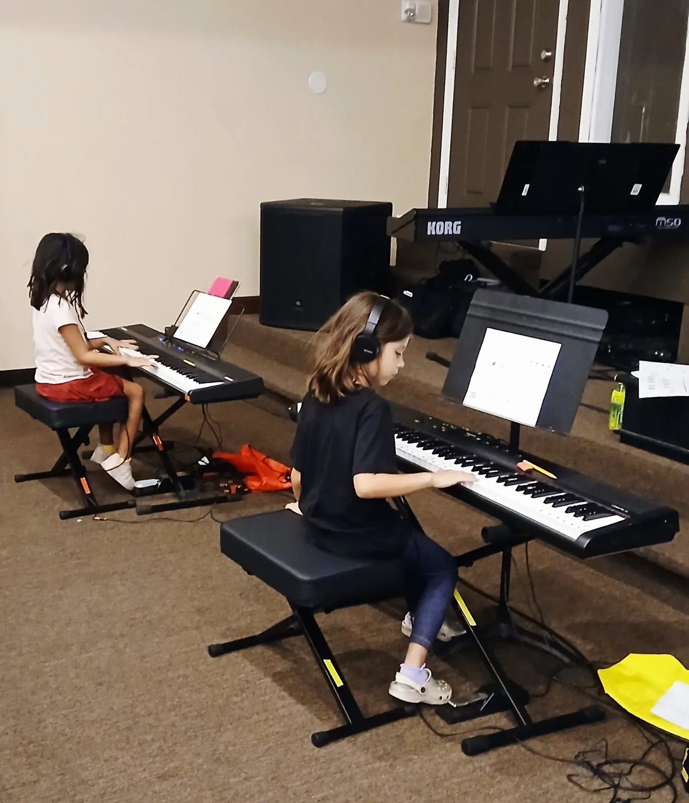 Two Spark Academy students practicing at keyboards